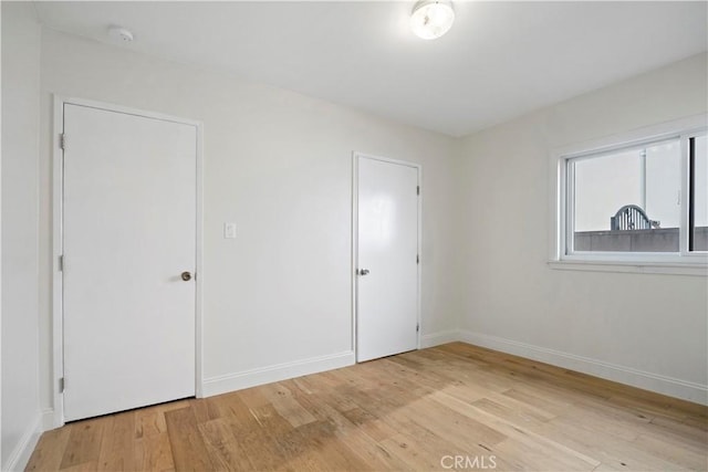 unfurnished bedroom featuring baseboards and light wood finished floors