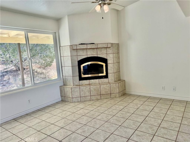 unfurnished living room featuring a fireplace, baseboards, and ceiling fan