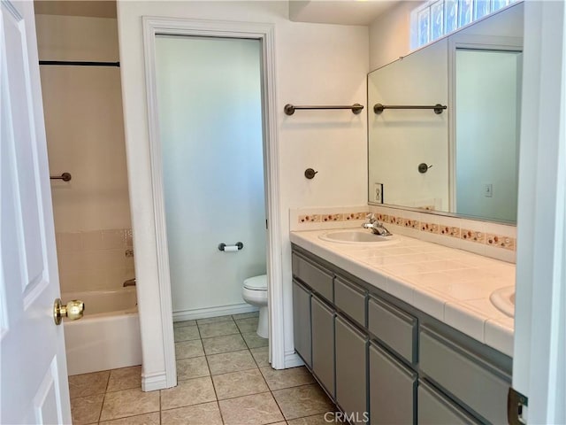 bathroom featuring double vanity, tile patterned flooring, a sink, and toilet