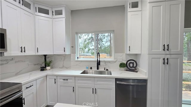 kitchen with white cabinets, glass insert cabinets, stainless steel appliances, and a sink