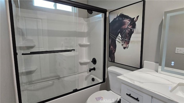 bathroom with enclosed tub / shower combo, vanity, and toilet