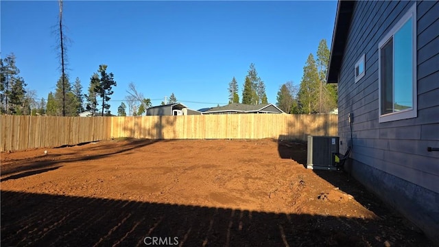 view of yard with a fenced backyard and central AC