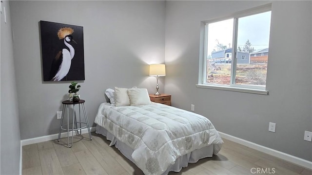 bedroom featuring light wood-style floors and baseboards