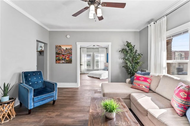 living area featuring a healthy amount of sunlight, crown molding, baseboards, and wood finished floors