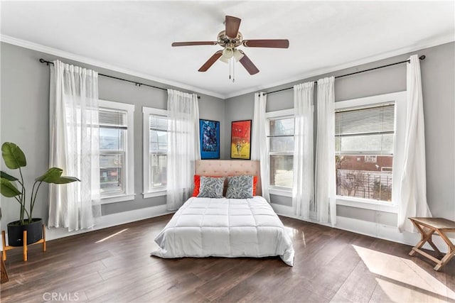 bedroom featuring ornamental molding, multiple windows, baseboards, and dark wood-style floors