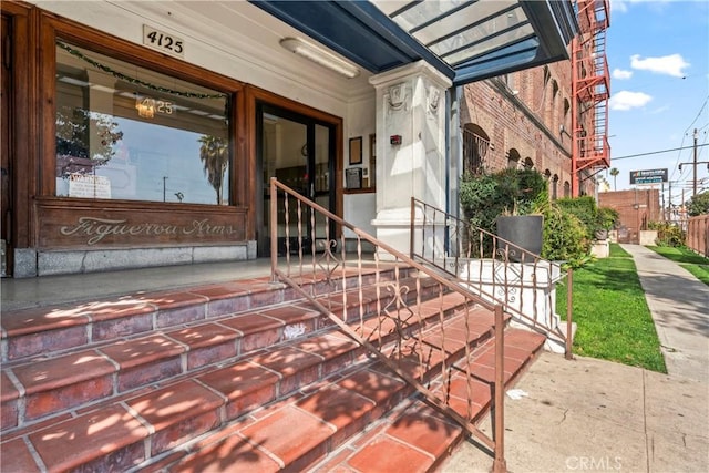 doorway to property featuring brick siding