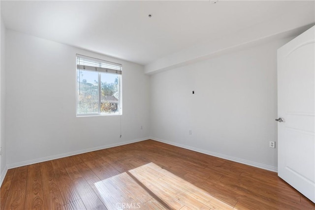 spare room with light wood finished floors and baseboards