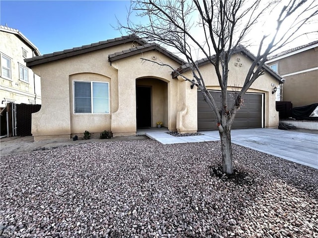 view of front of property with driveway, a tiled roof, an attached garage, and stucco siding