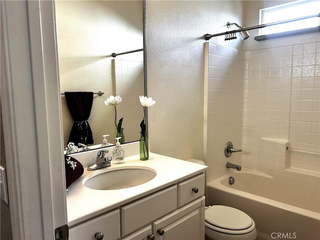 full bathroom featuring a textured wall, bathtub / shower combination, vanity, and toilet