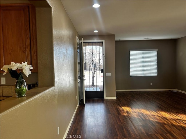 foyer featuring baseboards, dark wood-type flooring, and recessed lighting