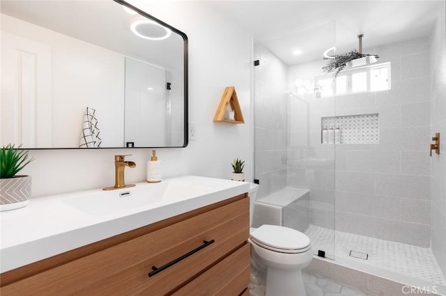 bathroom featuring vanity, toilet, and tiled shower