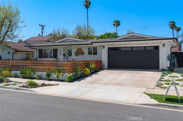 single story home with stucco siding, fence private yard, concrete driveway, and an attached garage