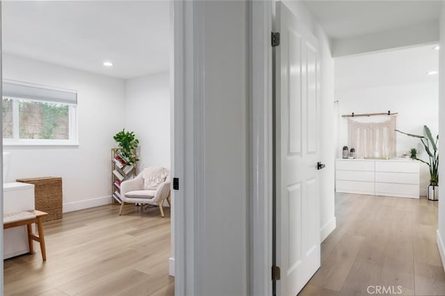hall with baseboards, recessed lighting, and light wood-style flooring