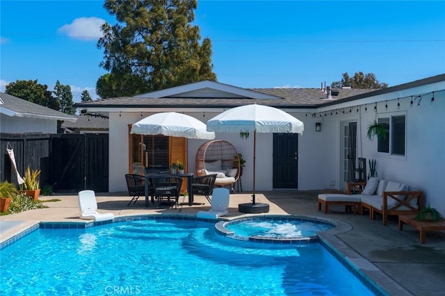 exterior space featuring fence, stucco siding, a pool with connected hot tub, and a patio area
