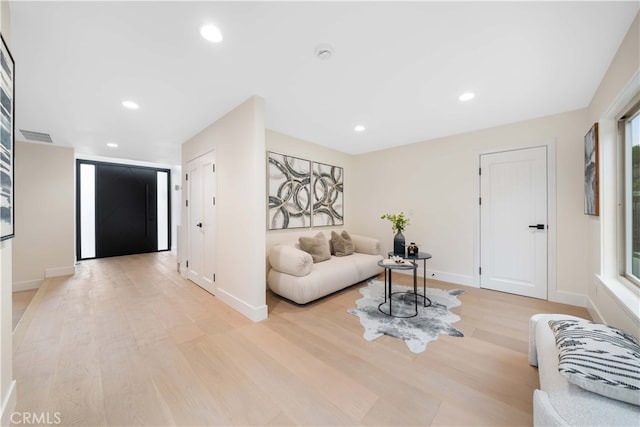 living area featuring light wood finished floors, visible vents, baseboards, and recessed lighting