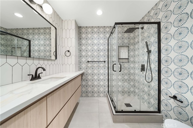 bathroom featuring a stall shower, tile patterned floors, vanity, tile walls, and recessed lighting