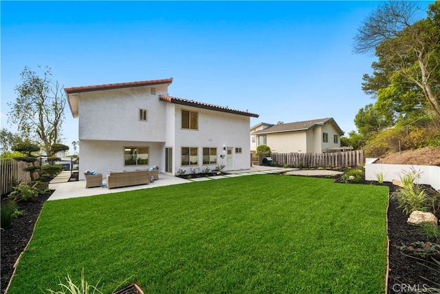 back of house featuring a patio, a fenced backyard, a yard, outdoor lounge area, and stucco siding