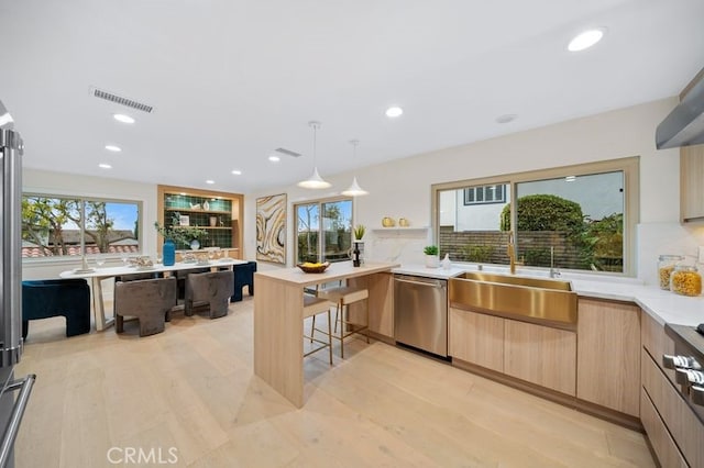 kitchen with visible vents, light brown cabinetry, a sink, modern cabinets, and dishwasher