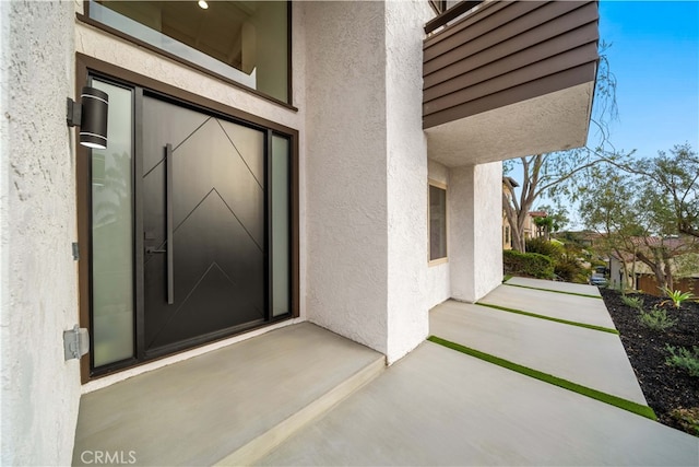 entrance to property featuring a patio and stucco siding