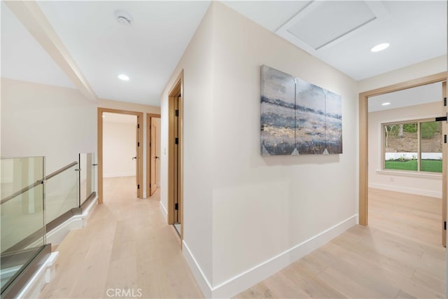 hallway with light wood-style floors, attic access, baseboards, and recessed lighting