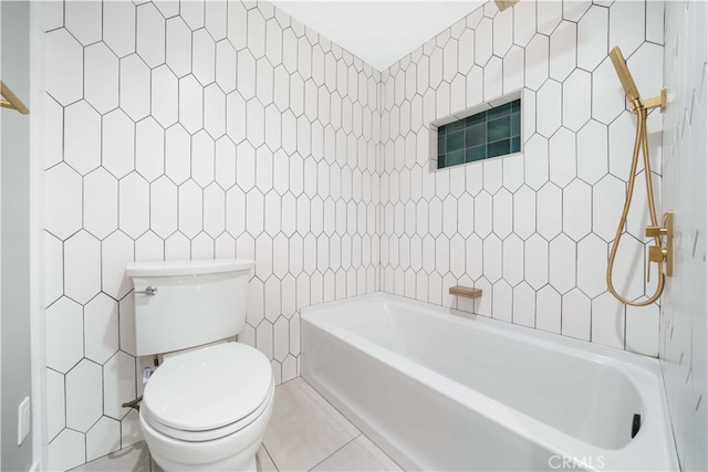 bathroom featuring toilet, a bathtub, and tile walls