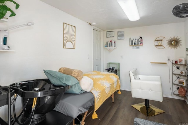 bedroom with baseboards and dark wood-type flooring