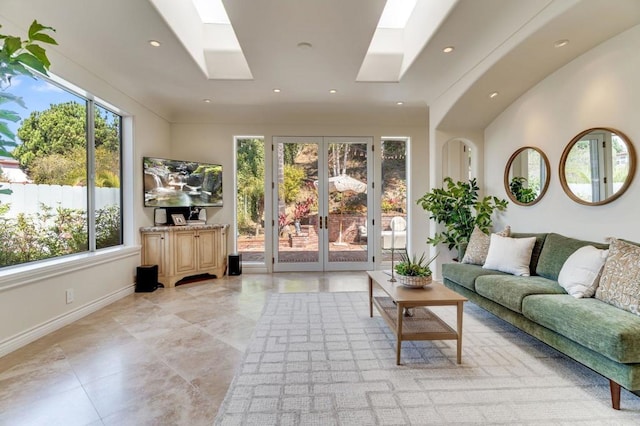 living room featuring baseboards, french doors, a skylight, and recessed lighting