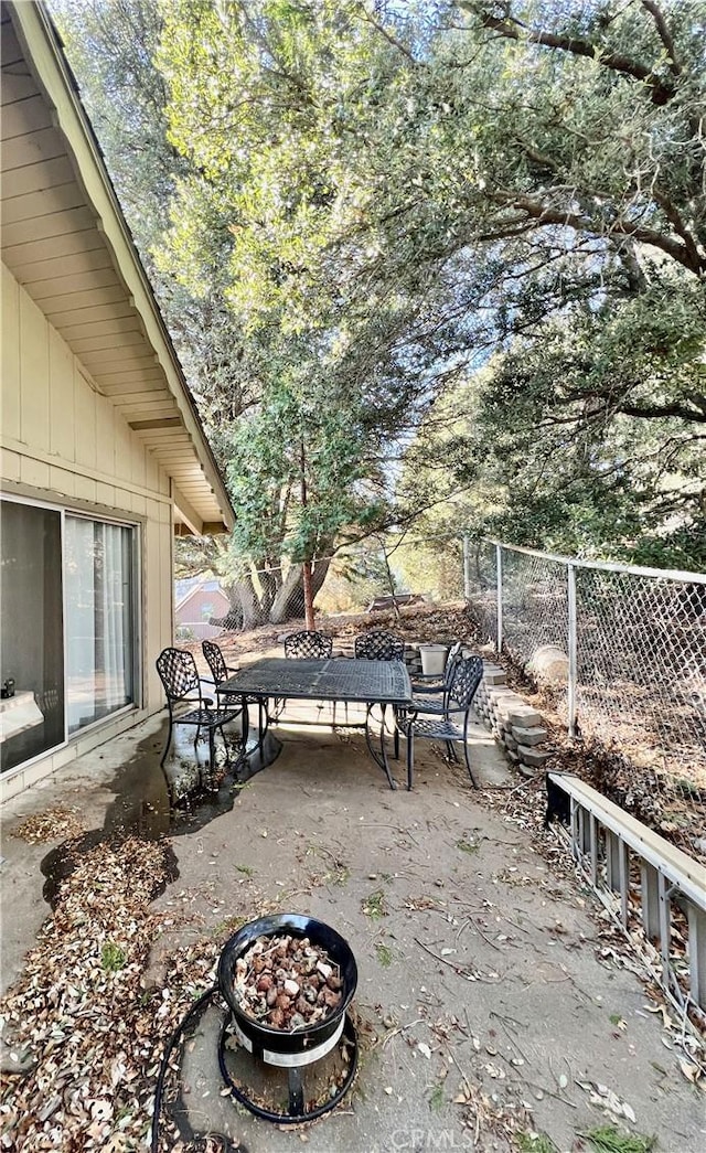 view of patio / terrace featuring a fire pit, fence, and outdoor dining area