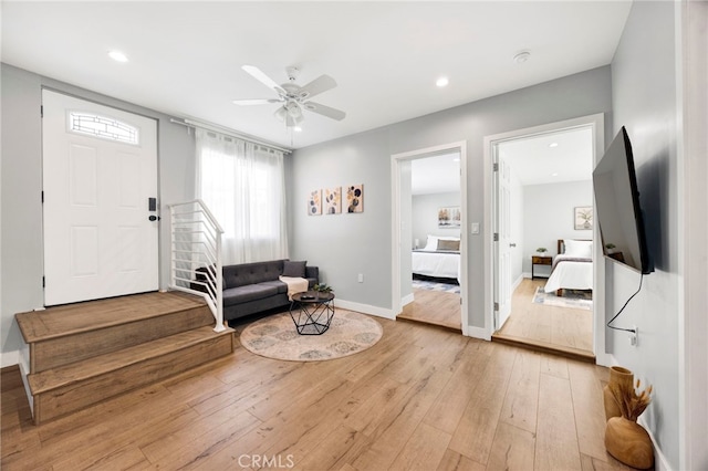 foyer entrance featuring light wood finished floors, recessed lighting, stairway, a ceiling fan, and baseboards