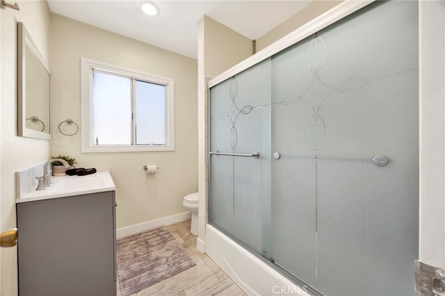 bathroom with baseboards, vanity, and toilet