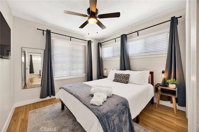 bedroom featuring a ceiling fan, baseboards, and wood finished floors