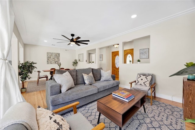 living area with crown molding, recessed lighting, ceiling fan, wood finished floors, and baseboards