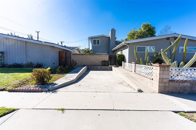 view of front facade featuring fence and stucco siding