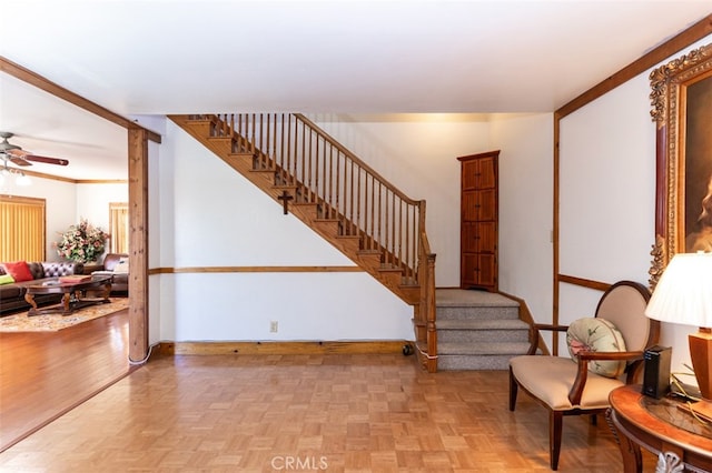 stairs featuring parquet flooring, ceiling fan, and baseboards