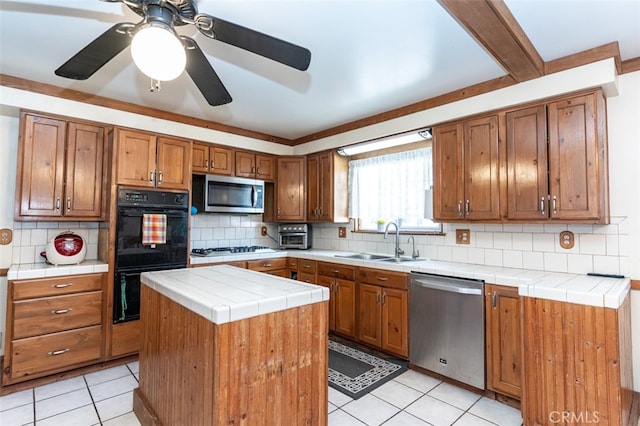 kitchen featuring a kitchen island, appliances with stainless steel finishes, brown cabinetry, and a sink