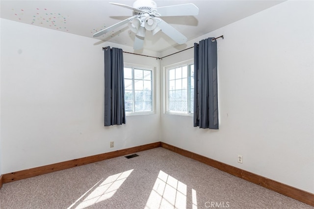 unfurnished room with light carpet, ceiling fan, visible vents, and baseboards