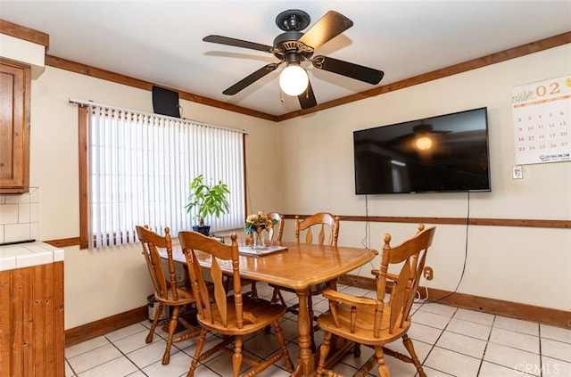 dining area with baseboards, a ceiling fan, and light tile patterned flooring