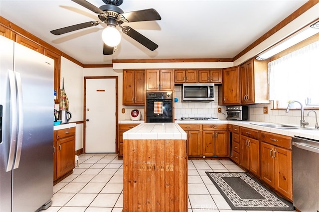 kitchen with tasteful backsplash, brown cabinetry, a center island, stainless steel appliances, and a sink