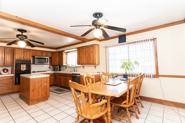 interior space with black appliances, a kitchen island, light countertops, and brown cabinets