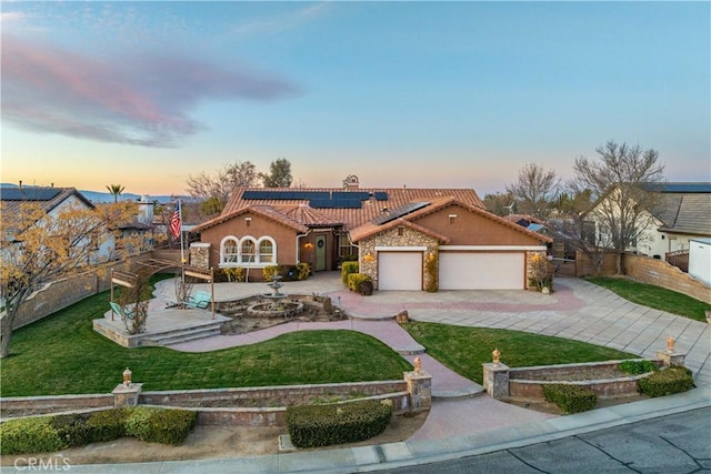 mediterranean / spanish-style home featuring a tiled roof, fence, driveway, and roof mounted solar panels