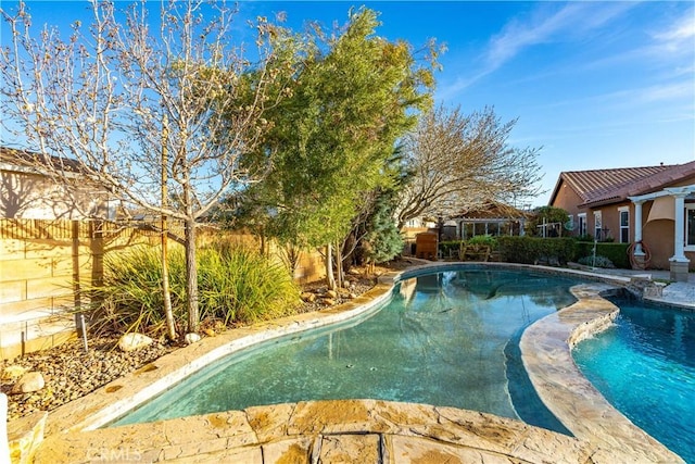 outdoor pool featuring a fenced backyard