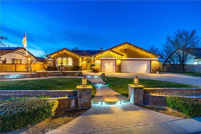 mediterranean / spanish house featuring driveway, a garage, fence, and a front yard