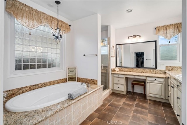 bathroom with a stall shower, a garden tub, vanity, and an inviting chandelier