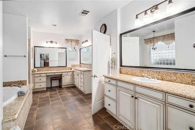 full bath featuring tiled bath, two vanities, a sink, and visible vents