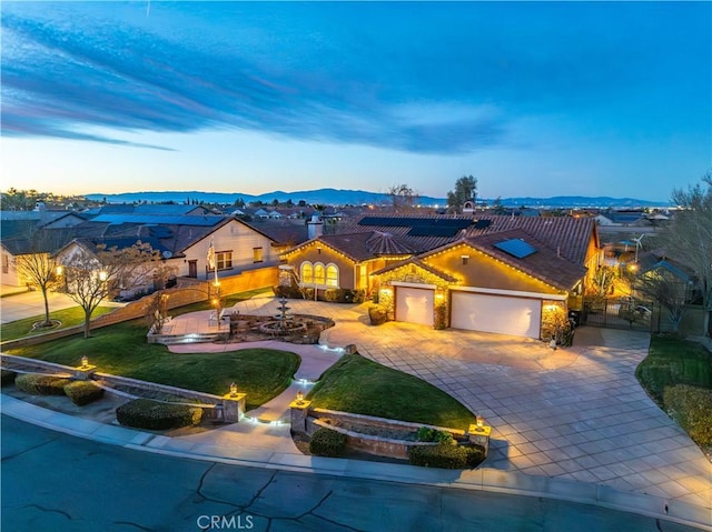 view of front of property featuring an attached garage, a mountain view, and decorative driveway