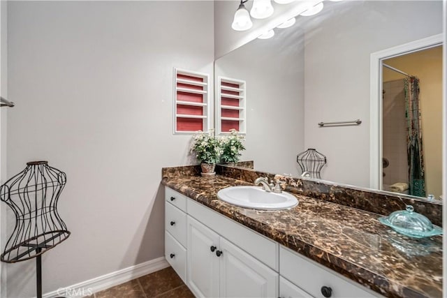 bathroom featuring a shower with shower curtain, tile patterned flooring, baseboards, and vanity