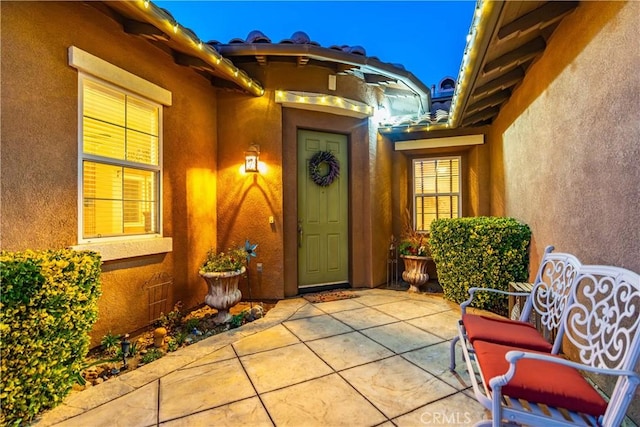 property entrance featuring a patio area and stucco siding