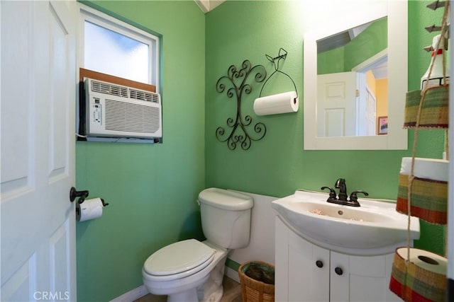 bathroom with toilet, a wall mounted AC, vanity, and baseboards