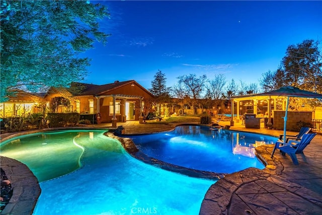 pool at dusk featuring a patio area, fence, and an outdoor pool