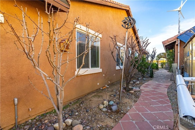 view of home's exterior featuring a tiled roof, a patio, and stucco siding